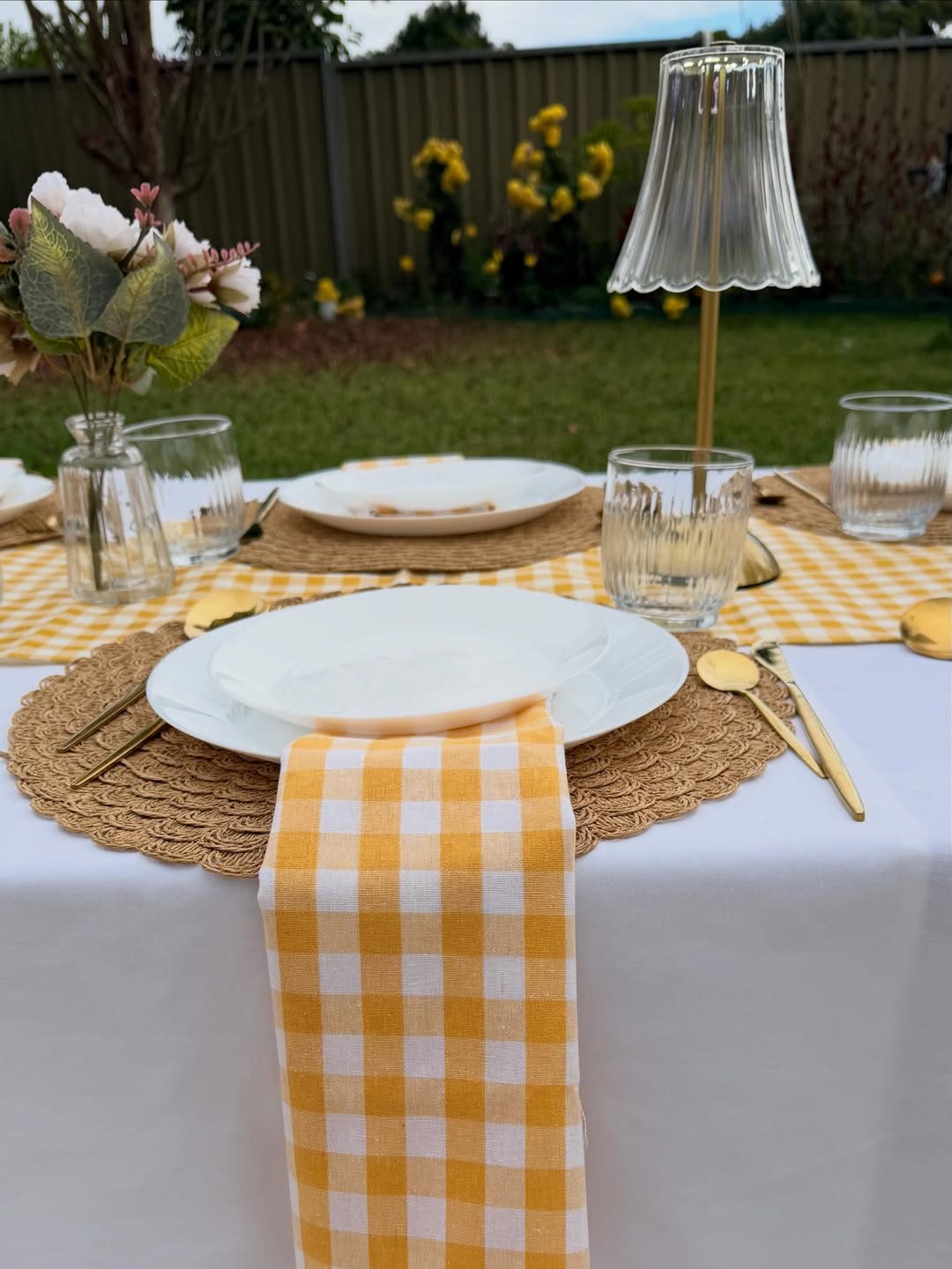 Yellow gingham DIY picnic kit laid out on the grass