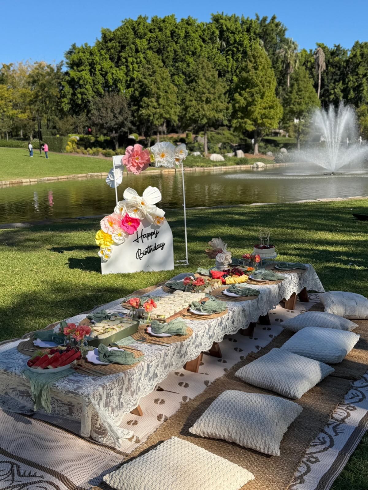 Birthday picnic setup by a park fountain